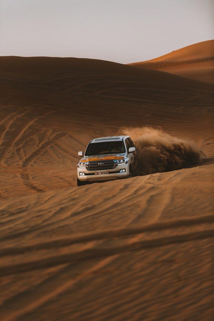 Rugged desert safari tour van navigating the dunes near Dubai, featured in our van rental services in Dubai.